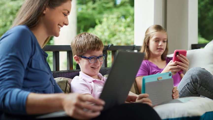 A woman and two children look at various screens