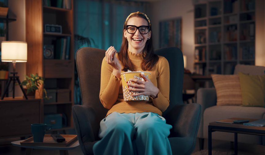 Expressive women with glasses eating popcorn